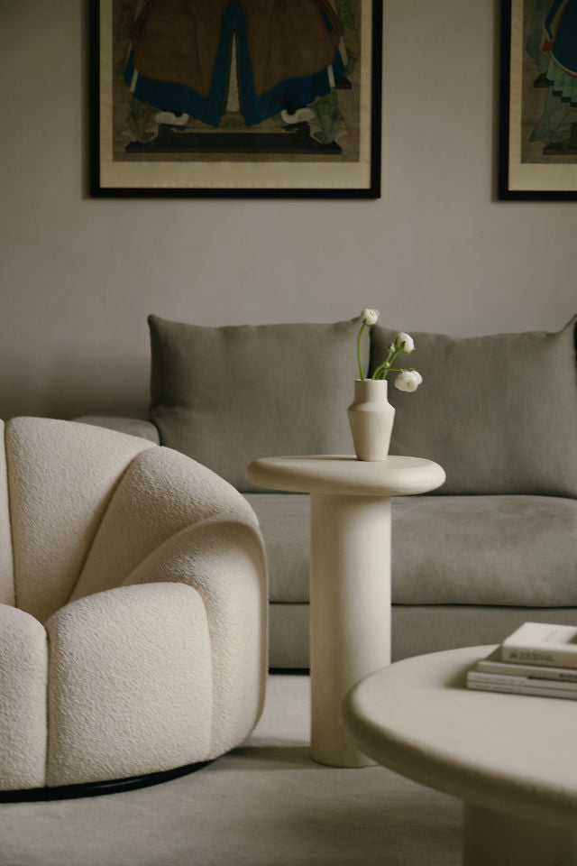 MAIE Clay Crème nesting tables featuring a subtly grained surface, styled with flowers and books in a neutral living room.