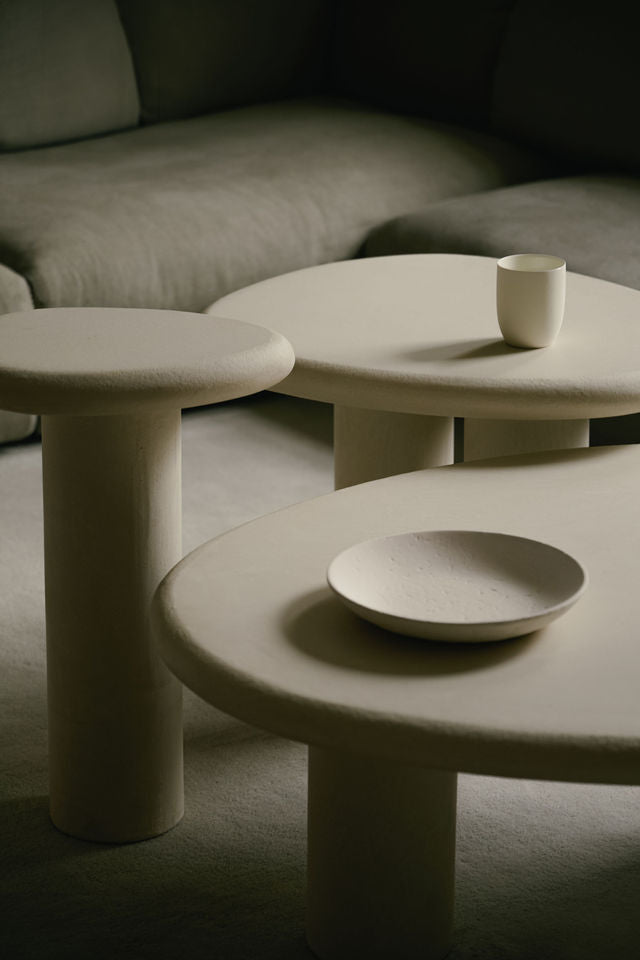 Organic-shaped nesting tables in Clay Crème with a subtly grained surface and rounded, asymmetrical form.