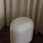 Sculptural MAIE side table in Clay Crème with a subtly grained surface and rounded, asymmetrical form.