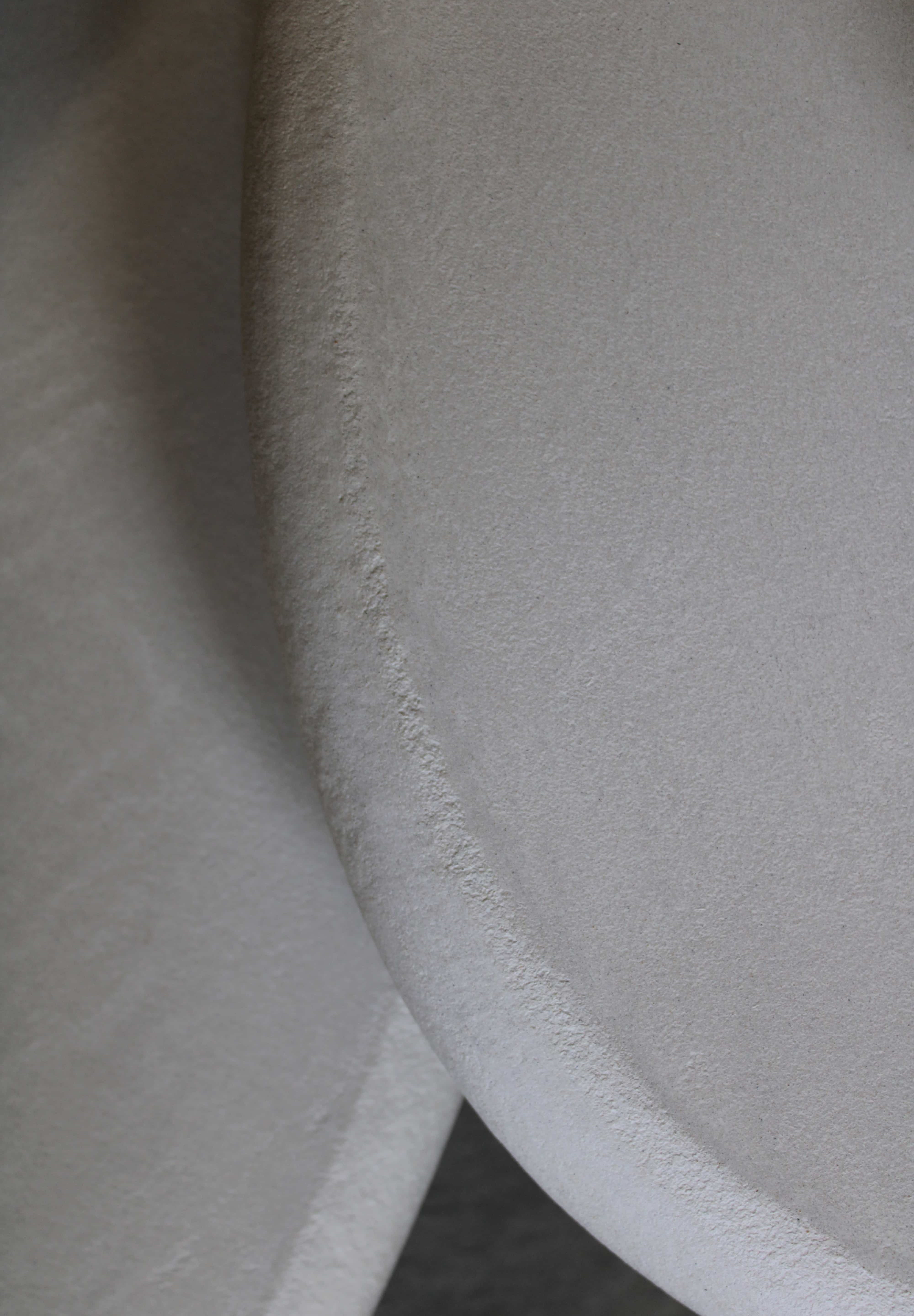 Close-up of Clay Duvet showing a subtle, fine grain across its tactile surface and softly rounded edge.