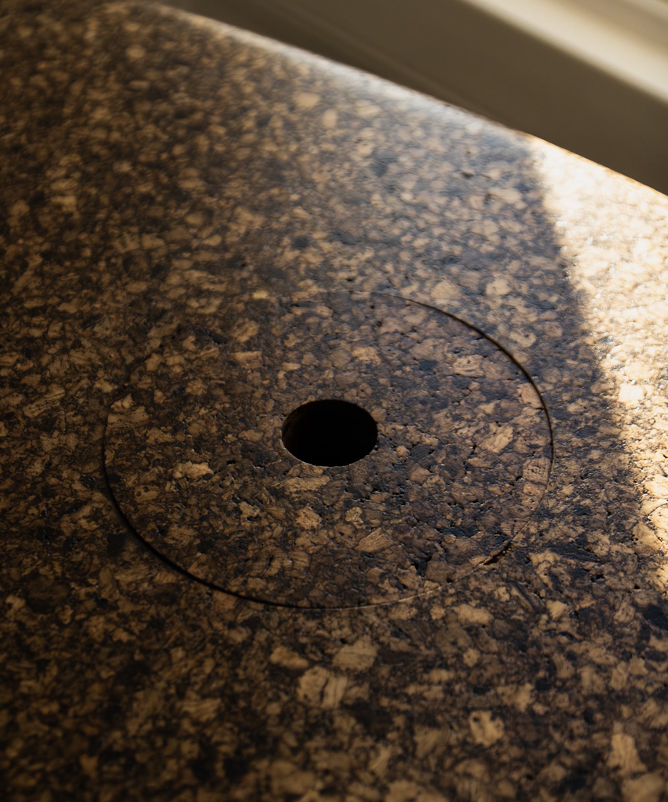 Close-up of Espresso cork showing its tactile, mottled texture and satin finish reflecting natural light.