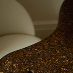 Sculptural MAIE desk in Espresso cork with a satin finish, organically curved tabletop and cylindrical legs.