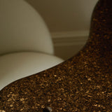 Sculptural MAIE desk in Espresso cork with a satin finish, organically curved tabletop and cylindrical legs.