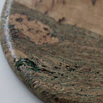 Close-up of the Marbled cork coaster showing soft green lines through warm cork grain and tactile texture.