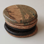 Stack of round cork coasters with the Marbled design on top, showing soft green lines through warm tan cork and a satin finish