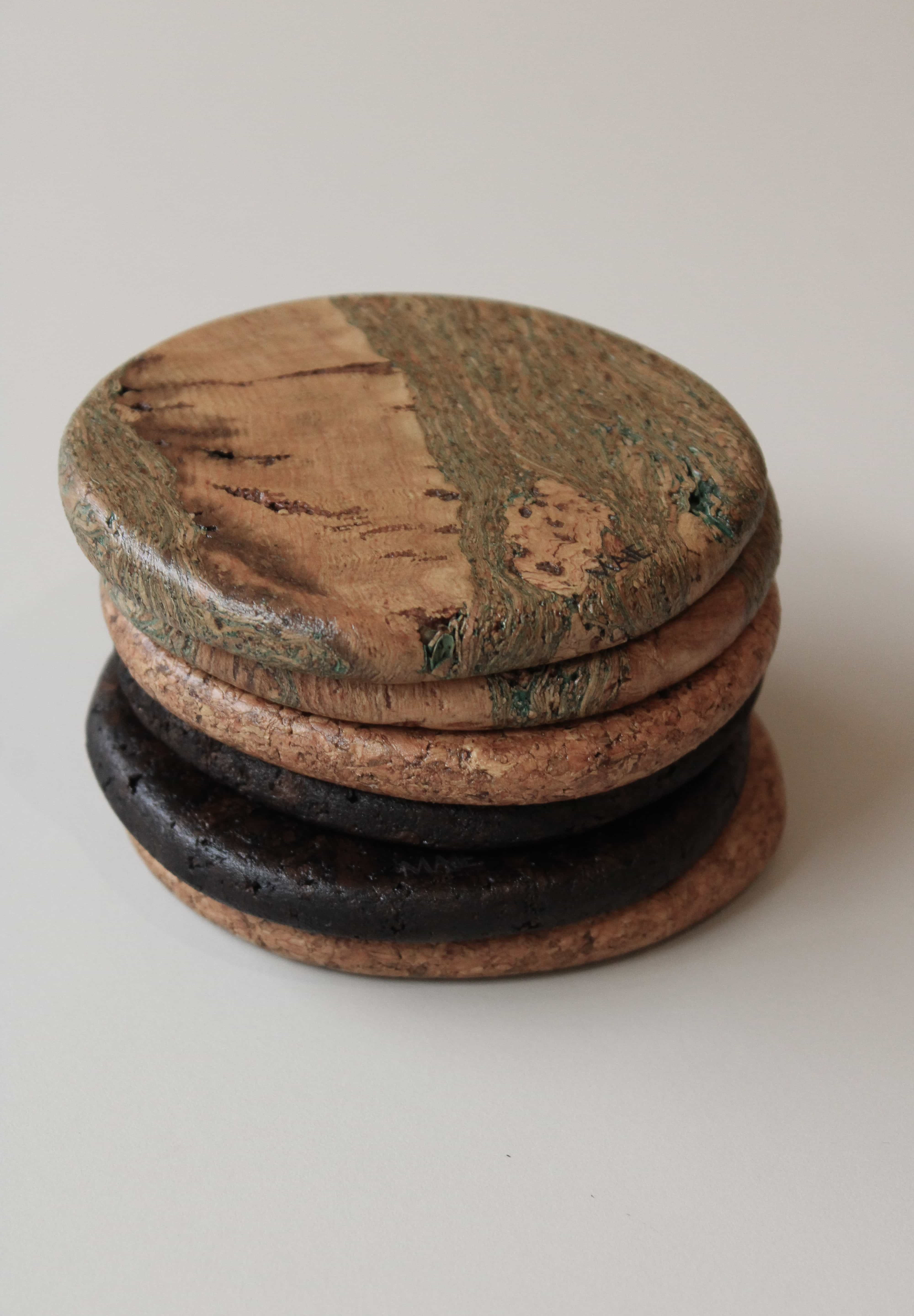 Stack of round cork coasters with the Marbled design on top, showing soft green lines through warm tan cork and a satin finish