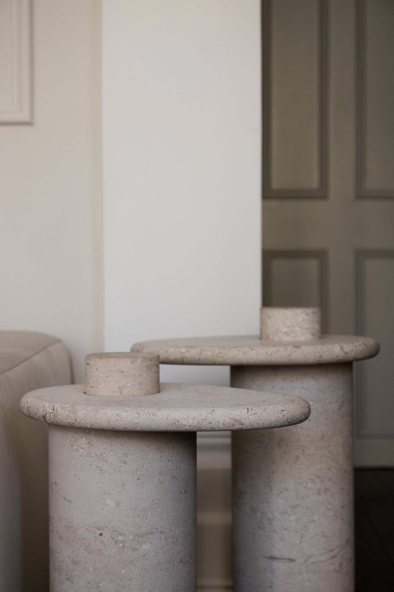 Honed Limestone Portland Side Table with an organically shaped tabletop and cylindrical pedestal, in pale grey-beige stone.