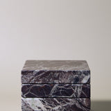 Stack of square MAIE coasters in Rosso Levanto, showing fine white veining across a rich burgundy-red surface.