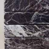 Close-up of Rosso Levanto marble coasters showing fine white veining across a rich burgundy-red surface.