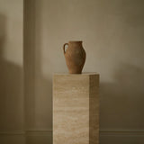 Angular Travertino Classico VC marble plinth with warm-toned veining, styled with a terracotta vase against natural soft interior.