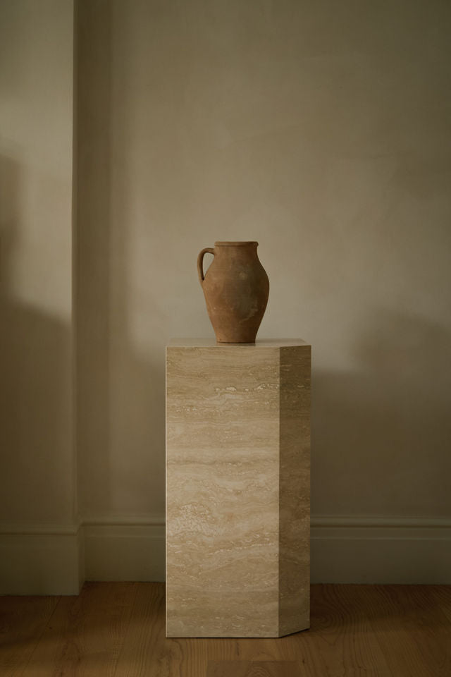 Angular Travertino Classico VC marble plinth with warm-toned veining, styled with a terracotta vase against natural soft interior.