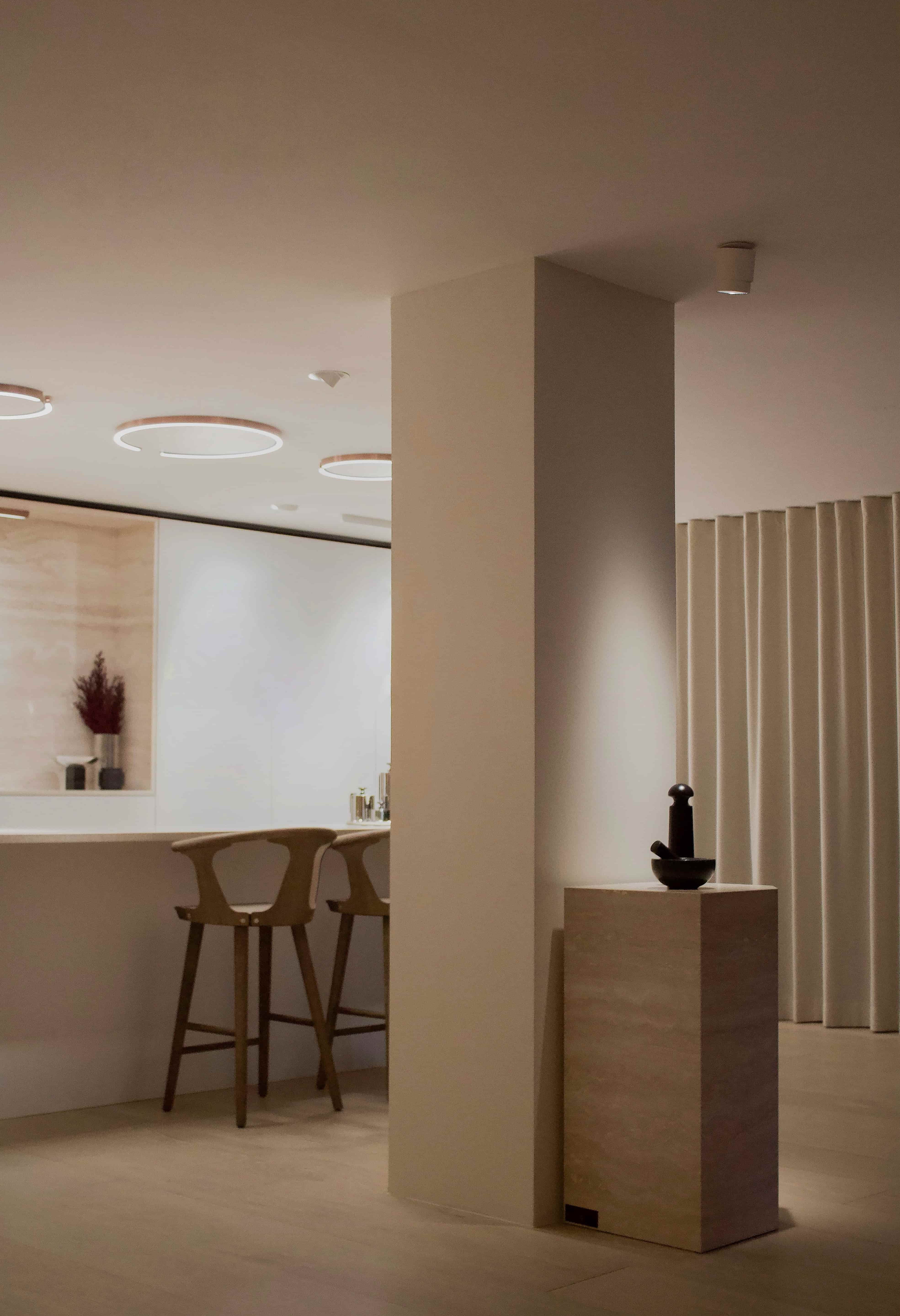 Angular Travertino Classico VC marble plinth with warm-toned veining, styled with a chrome tea set against in a soft contemporary interior.