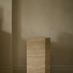 Angular Travertino Classico VC marble plinth with warm-toned veining against a natural soft interior.