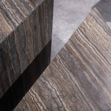 Close-up of Travertino Marrone showing natural pores, irregular veining and layered grey-brown tones along stacked stone edges.