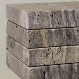 Close-up of Travertino Marrone showing natural pores, irregular veining and layered grey-brown tones along stacked stone edges.