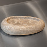 Egg-shaped Travertino Classico CC marble bowl with warm-toned veining on a stainless steel surface.