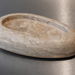 Egg-shaped Travertino Classico CC marble bowl with warm-toned veining on a stainless steel surface.