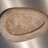 Egg-shaped Travertino Classico CC marble bowl with warm-toned veining on a stainless steel surface.